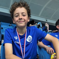Junior smiling with a silver medal around his neck
